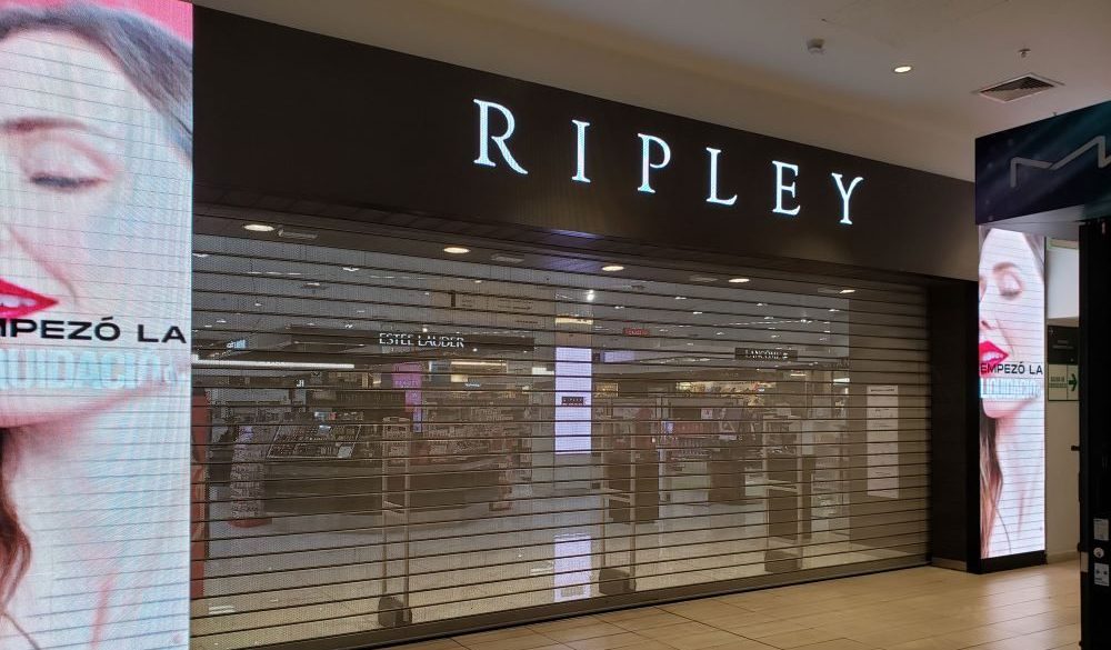 Puerta enrollable metálica Full Vision en tienda Ripley dentro de centro comercial, con diseño microperforado que mejora la iluminación interior y resguarda el local.