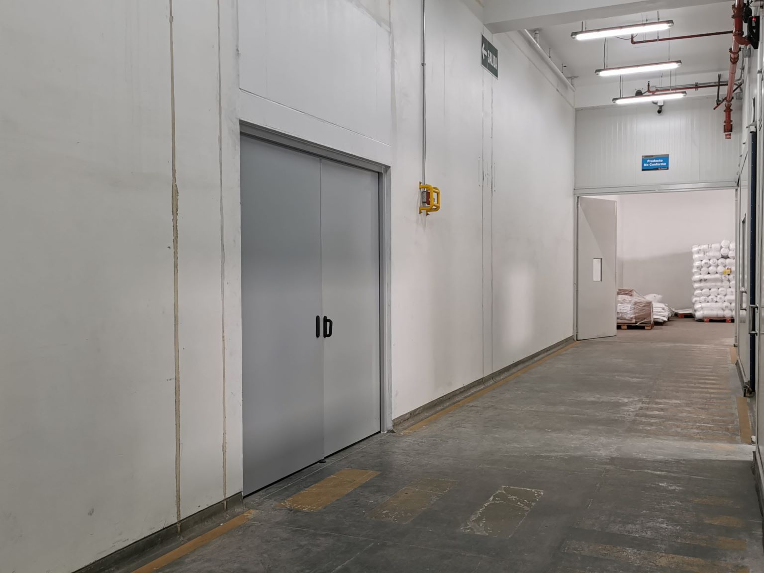 Puerta cortafuego instalada en entorno logístico de almacén, fabricada en medidas estándar o especiales según requerimientos del proyecto, diseñada para limitar la propagación del fuego y facilitar la evacuación, protegiendo personas y activos según su resistencia.