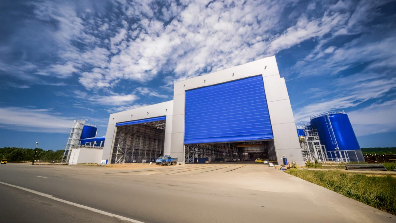 Puertas plegables de PVC para hangares en entorno industrial, con diseño sin ocupación lateral que optimiza el espacio, apertura vertical eficiente y funcionamiento confiable en operaciones exigentes.