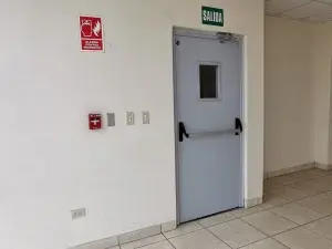 Puerta cortafuego instalada en edificio, diseñada para controlar incendios, limitar la propagación del fuego y facilitar la evacuación, cumpliendo normas y certificaciones vigentes en Perú.