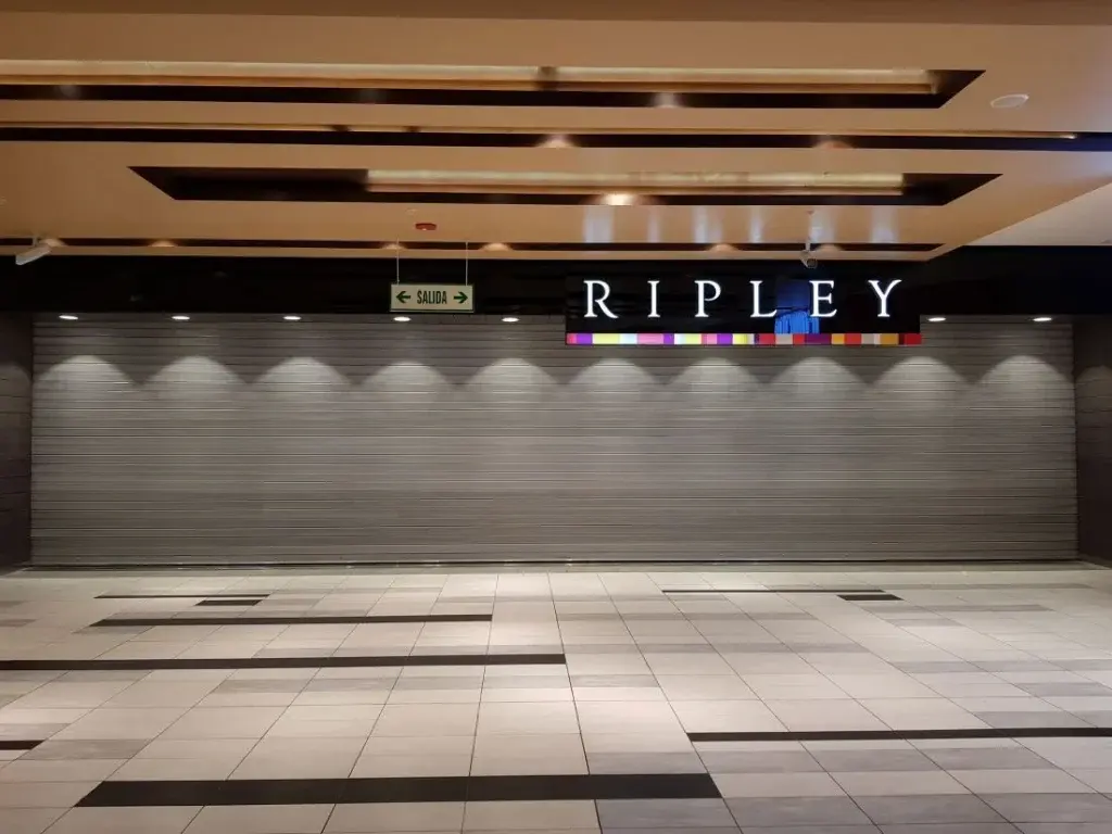 Puerta enrollable metálica comercial Cassadó instalada en tienda Ripley para seguridad en retail en Perú